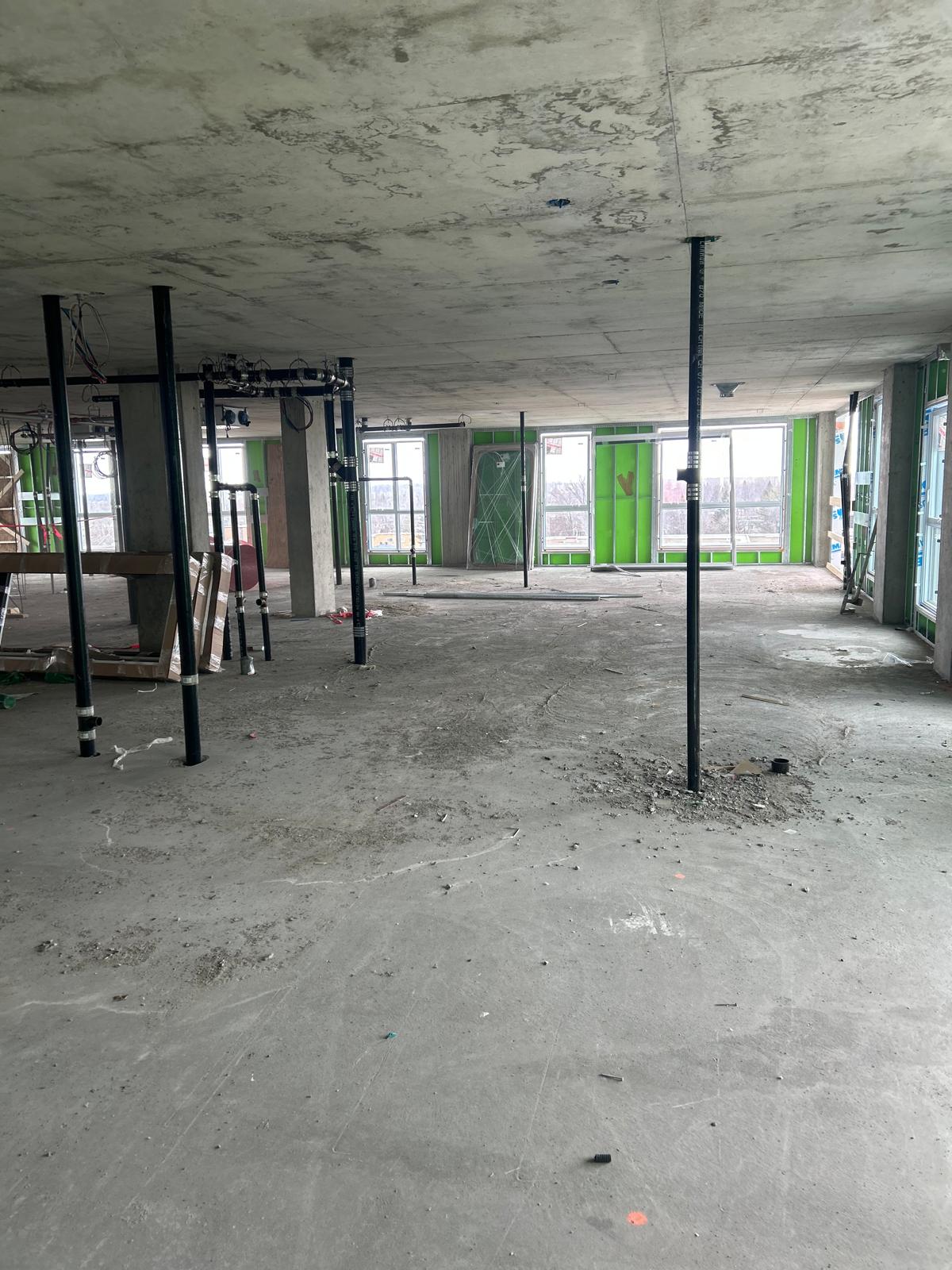 Plateau ouvert avant nettoyage de chantier avec plastiques, résidus et poussières au sol