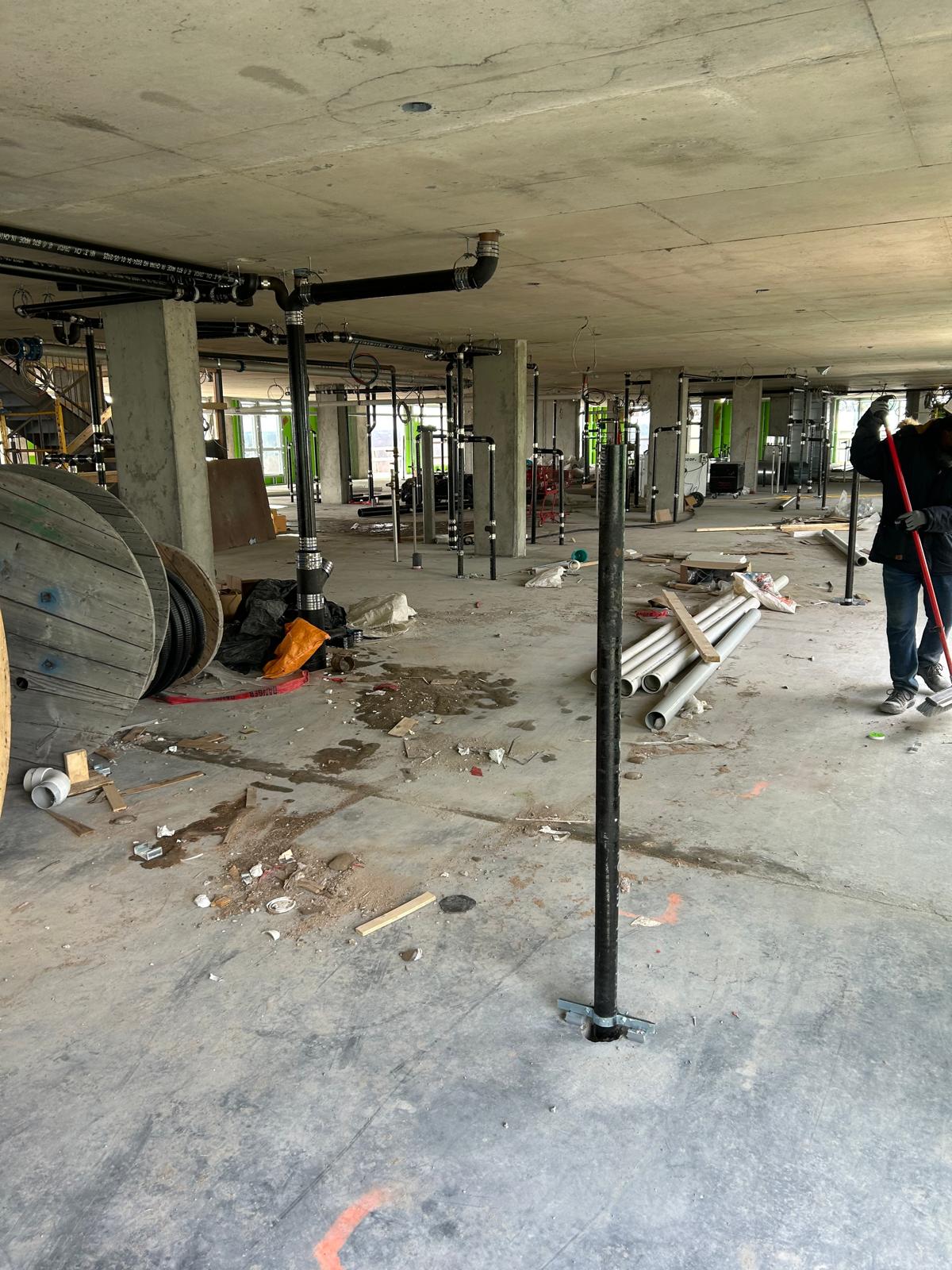 Zone intérieure avant nettoyage de chantier avec matériaux et salissures près de la façade