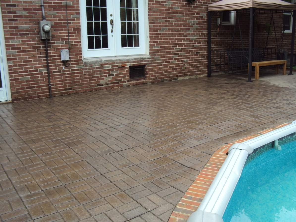Patio résidentiel en bordure de piscine après nettoyage et désherbage