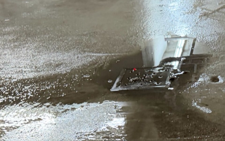 Poussière et résidus humides autour d'un drain de plancher avant le rinçage à pression du garage à Montréal